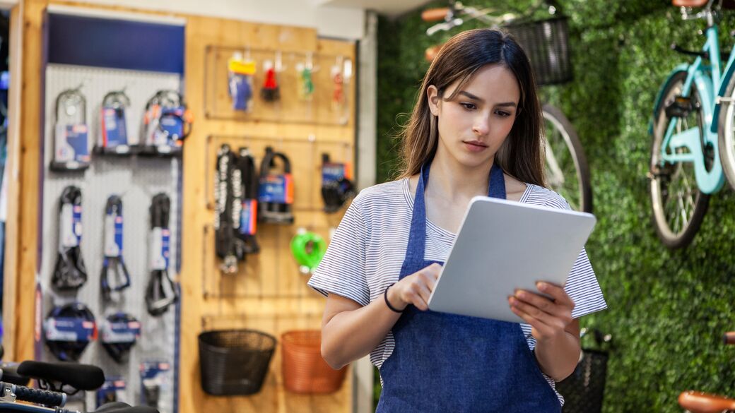 female shop owner holding digital tablet